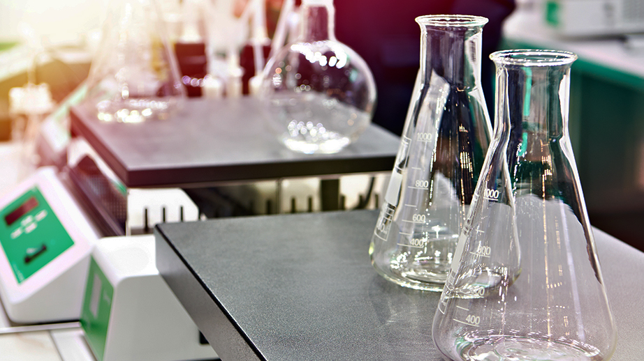 Op twee weegschalen staan een aantal glazen flessen. Het zijn erlenmeyers. Die worden gebruikt in chemie en farmacie. De weegschalen zijn industrieel.